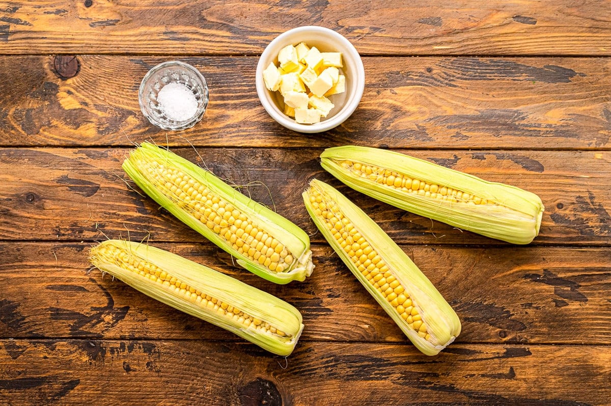 Overhead image of corn on the cob, salt and butter.