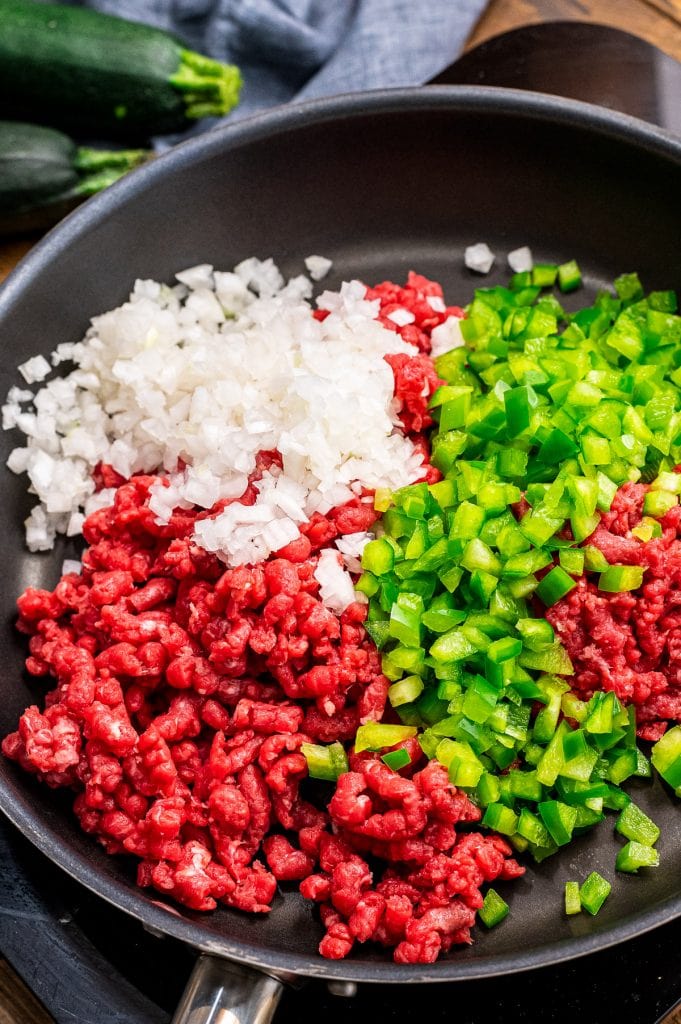 Skillet with ground beef, green pepper and onions before cooking