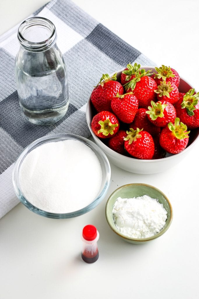 Ingredients for homemade strawberry sauce including sugar, cornstarch, strawberries, water and red food coloing