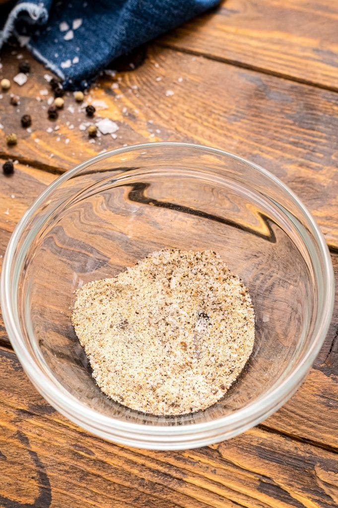 Glass bowl with a combination of garlic powder, salt and pepper mixed up.