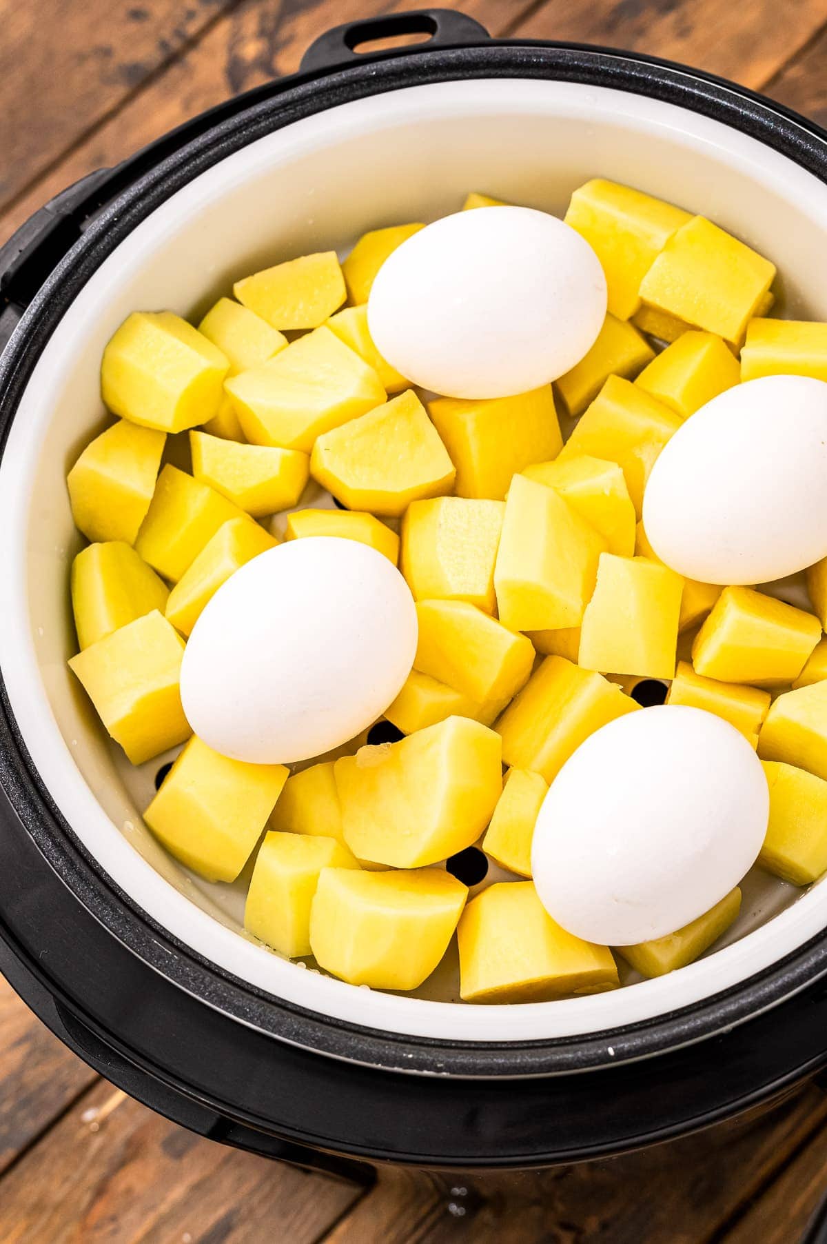 Instant Pot filled with raw potatoes and eggs before cooking