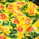 Cast iron skillet with cooked Spinach and Tomato Frittata