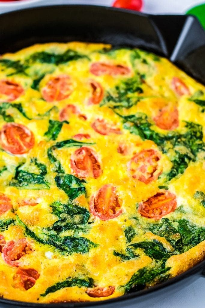 Cast iron skillet with cooked Spinach and Tomato Frittata