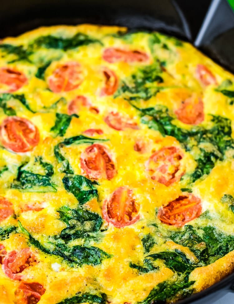 Cast iron skillet with cooked Spinach and Tomato Frittata