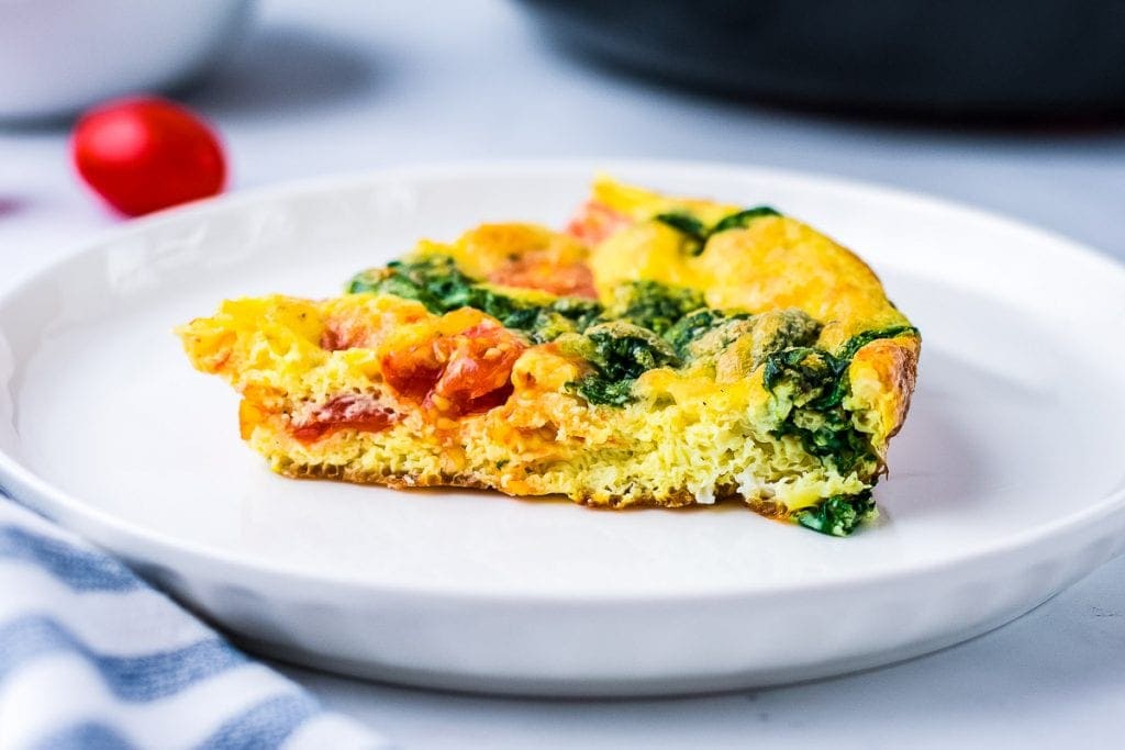 White plate with a slice of Spinach Frittata on it