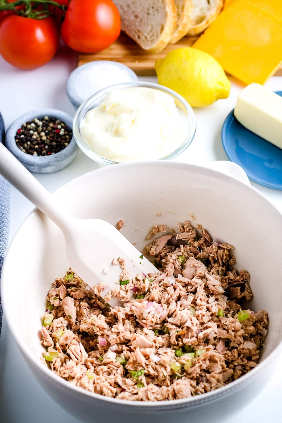 White bowl with tuna, celery, re onion and parsley mixed together