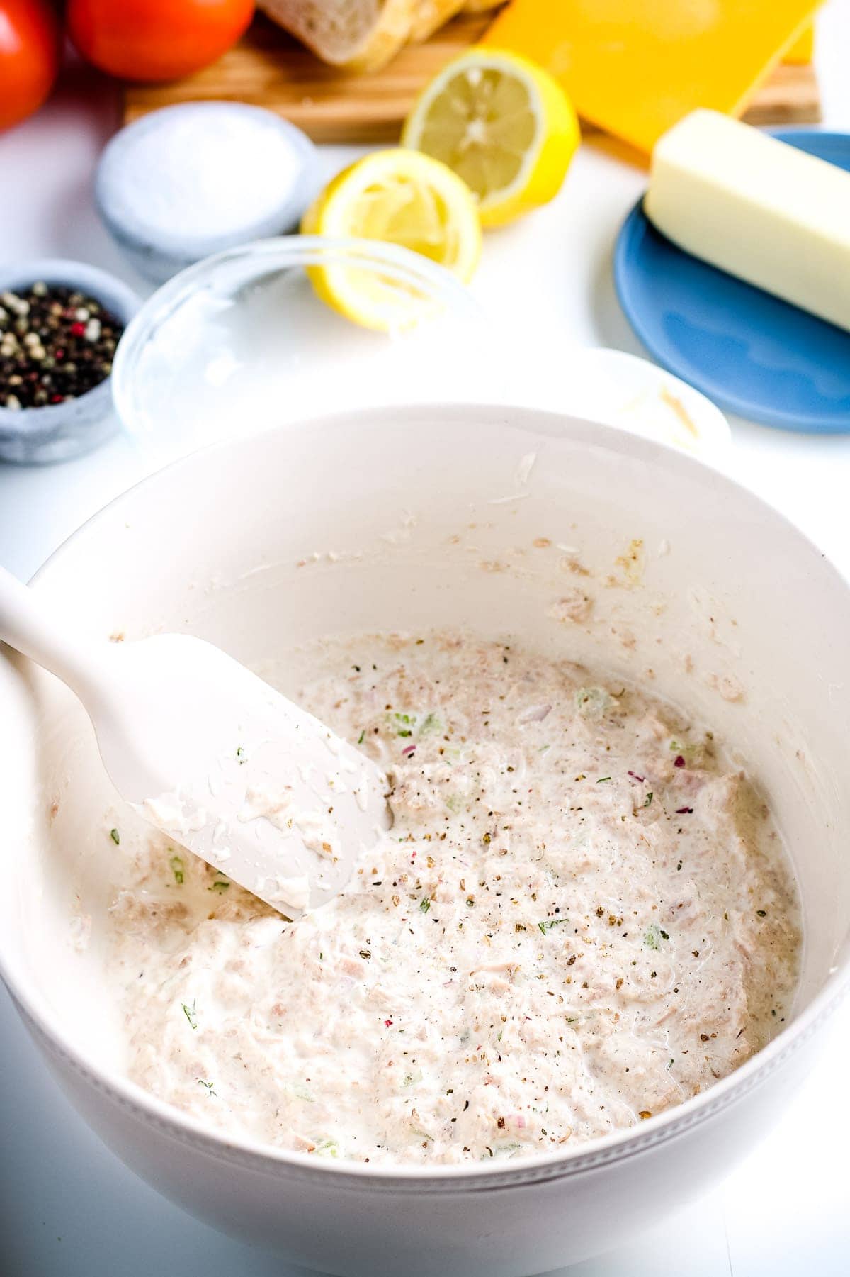 White bowl with tuna melt mixture mixed together then sprinkled with salt and pepper.