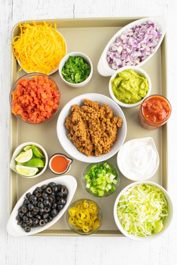 Overhead photo of sheet pan with bowls of taco toppings