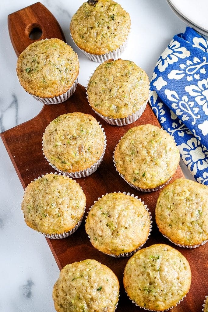 Overhead image of zucchini muffins on wood cutting board.