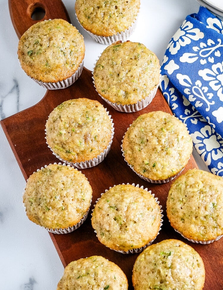 Overhead image of zucchini muffins on wood cutting board.