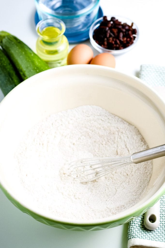 Off White bowl with flour, sugar, baking powder, baking soda, salt and cinnamon after mixing