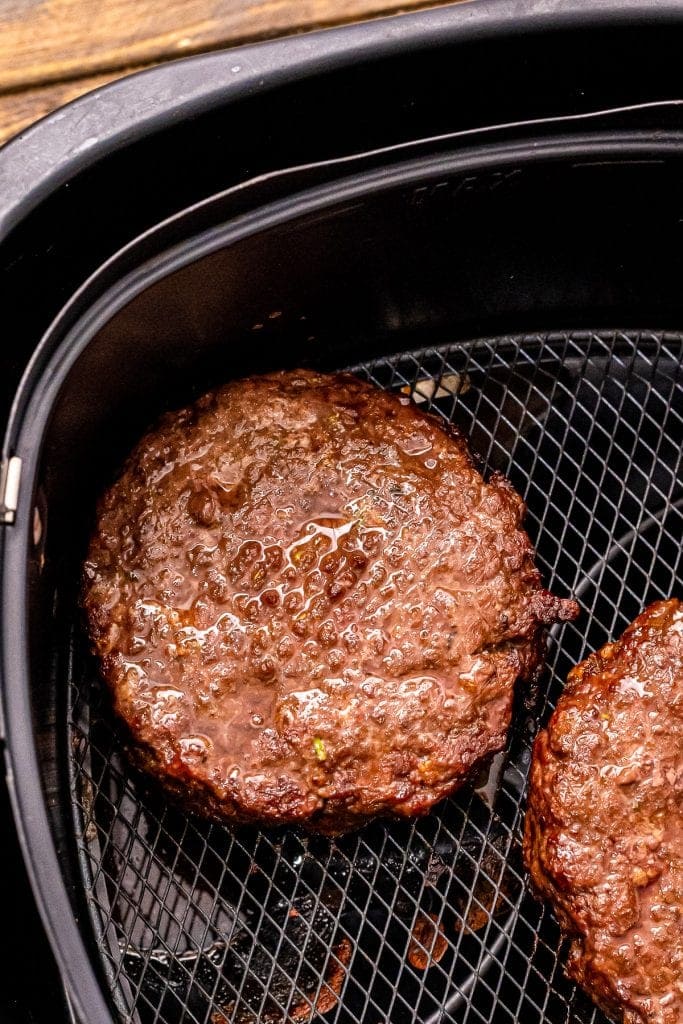 Cooked burgers in air fryer basket