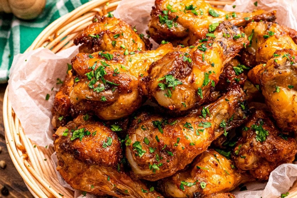Bowl with chicken wings garnished with chopped parsley.