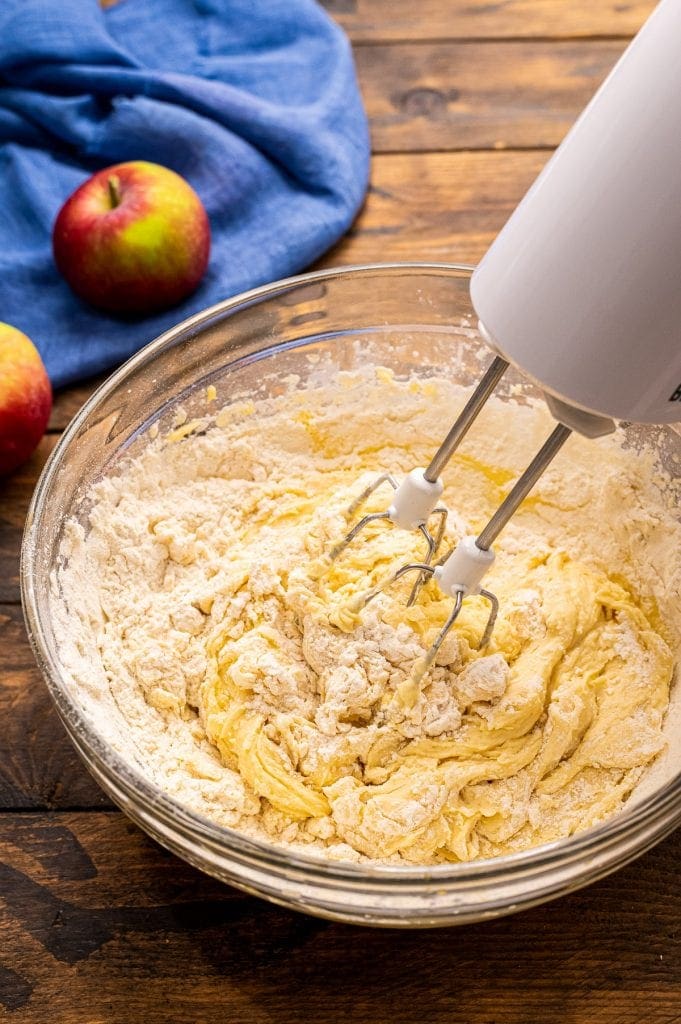 Hand mixer blending wet and dry ingredients together