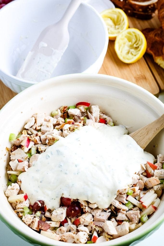 Bowl with chicken salad in it and dressing on top before mixing.