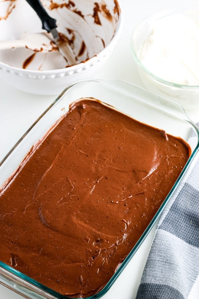 Glass dish with chocolate lasagna showing chocolate pudding layer.