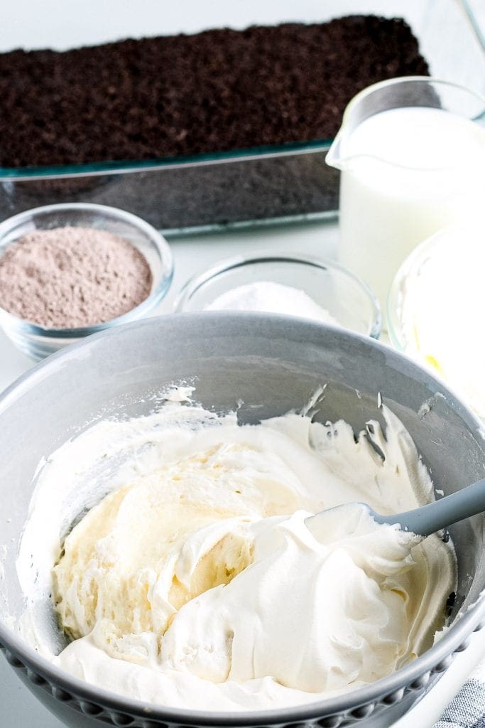 Gray bowl with cream cheese mixture and cool whip before mixing.