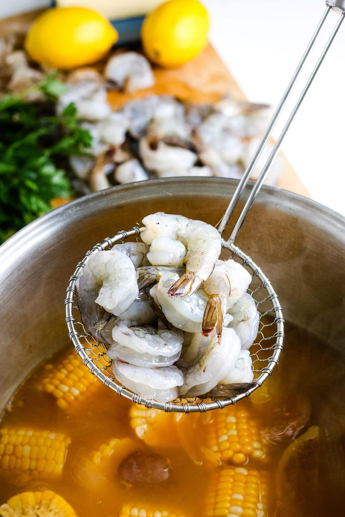 Ladle placing raw shrimp into shrimp boil