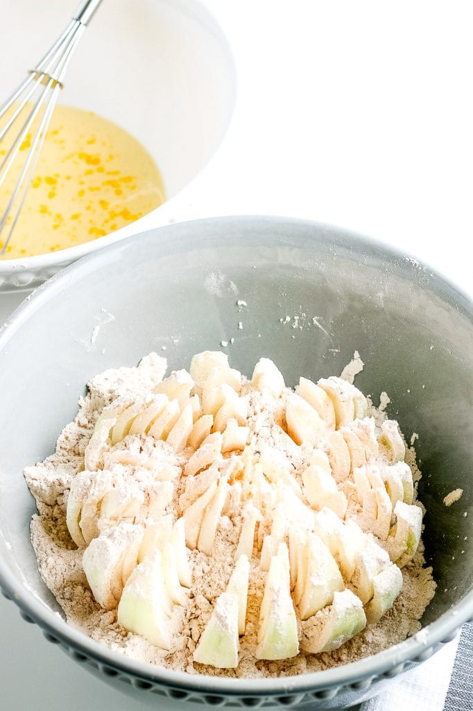 Onion cut side up in bowl with flour.