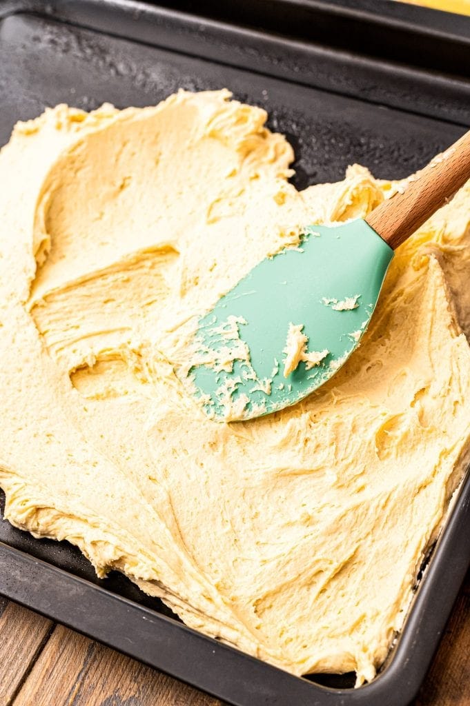 Spatula smoothing batter for crust into pan.