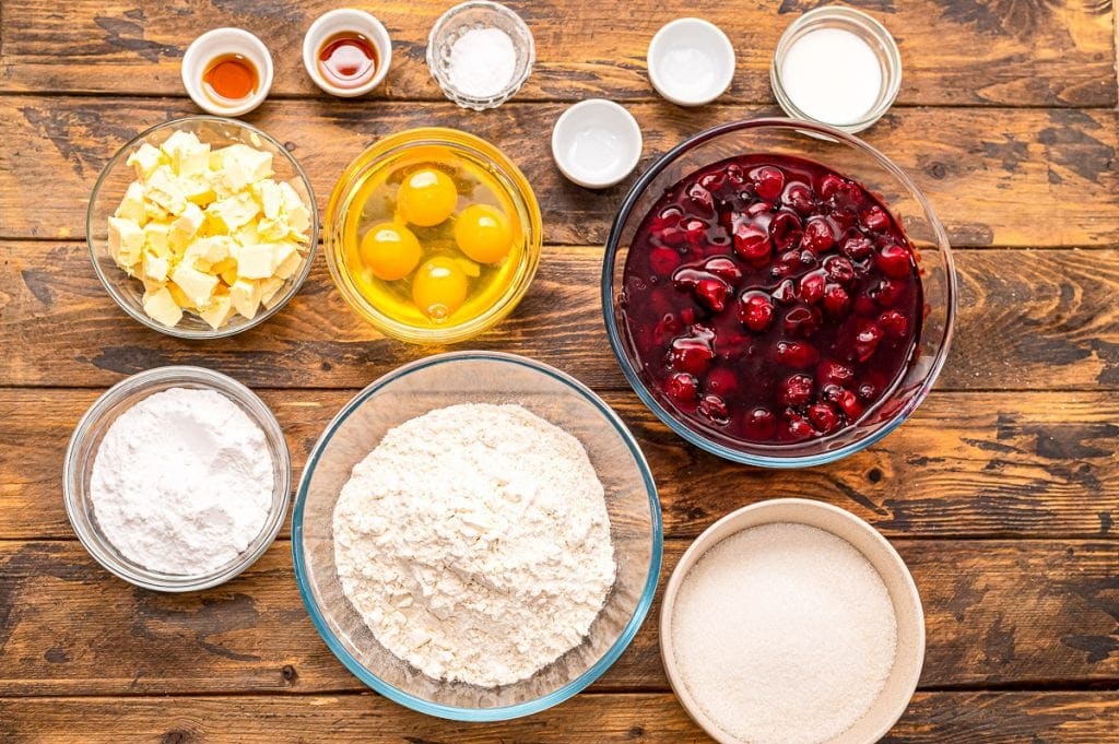 Overhead image of ingredients for Cherry Pie Bars in glass baking dishes