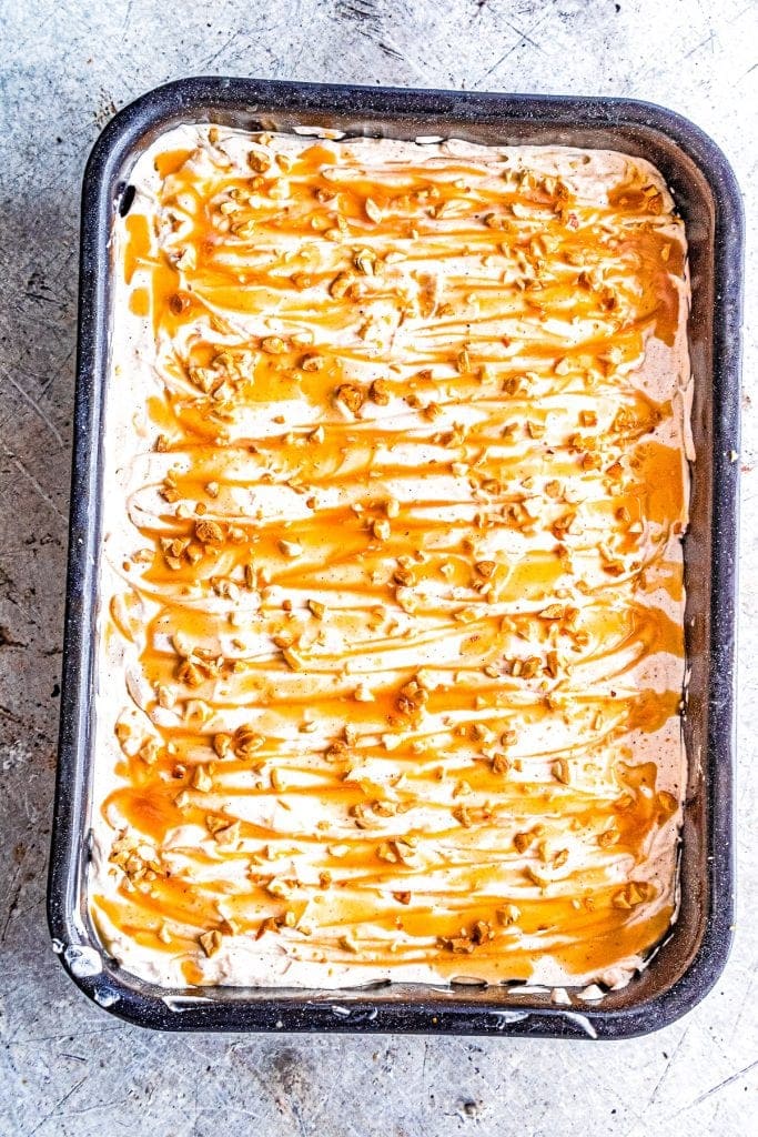 Dulce de Leche Apple Poke Cake Overhead in Pan topped with caramel and nuts