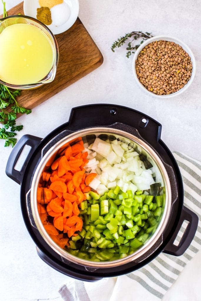 Instant Pot with chopped carrots, celery and onions in it.