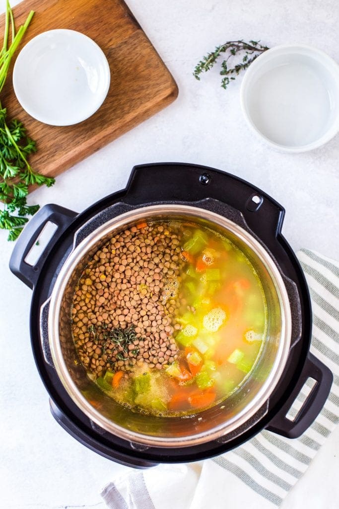 Instant Pot with ingredients in it to make Instant Pot Lentil Soup.