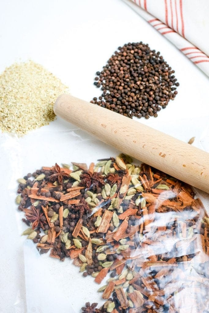 Mulling Spices in sealed plastic bag with rolling pin crushing them.