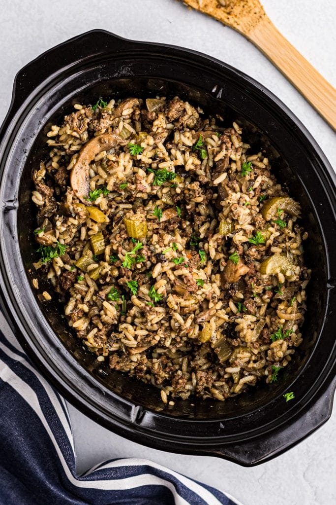 Black Crock Pot with Crock Pot Hamburger Wild Rice Casserole in it.