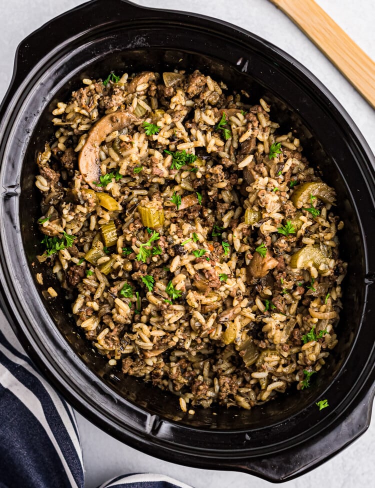 Black Crock Pot with Crock Pot Hamburger Wild Rice Casserole in it.