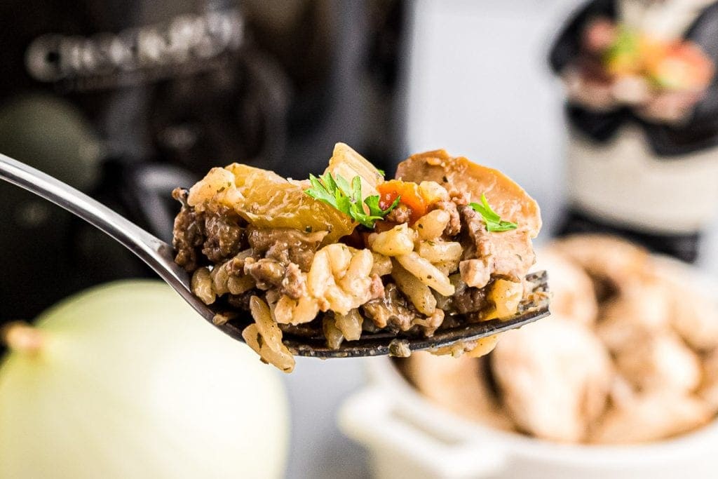 A spoon with a scoop of Crock Pot Hamburger Wild Rice Casserole on it.