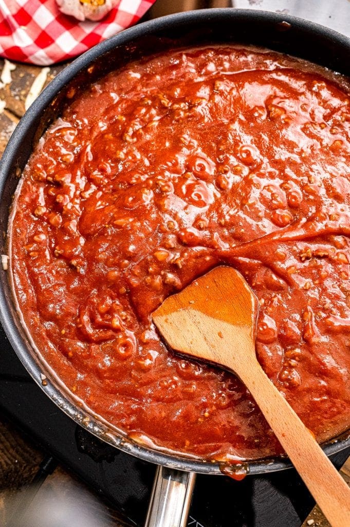 Meat sauce in black skillet with wooden spoon