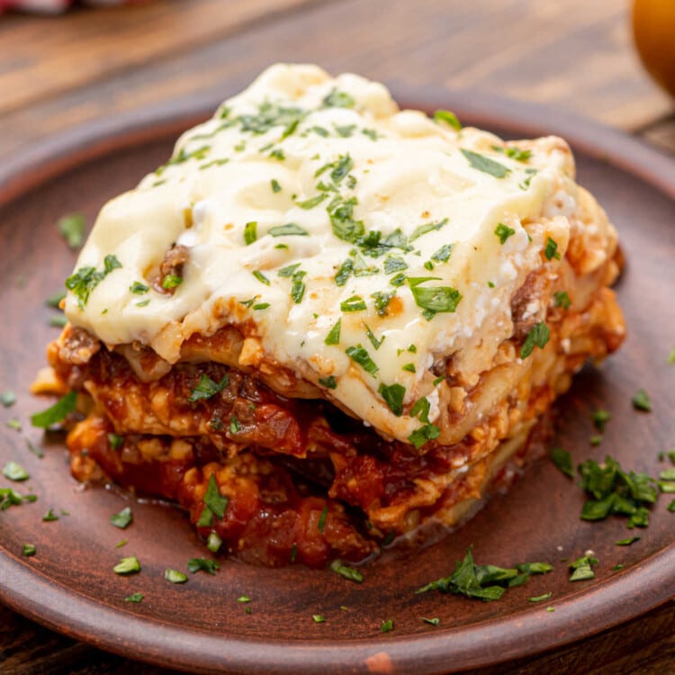 Piece of prepared lasagna on wooden plate