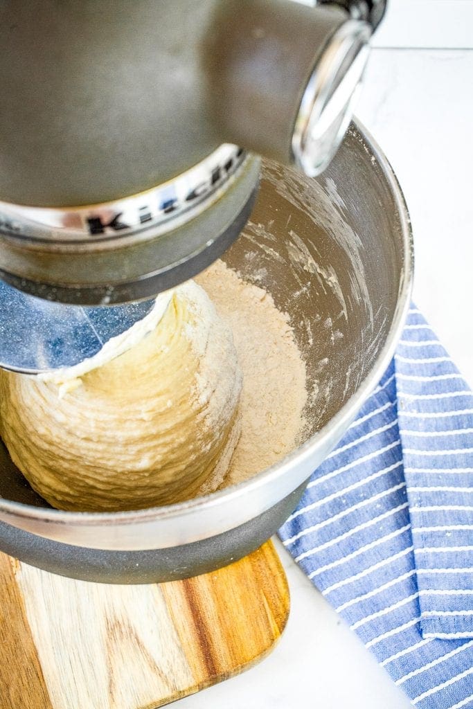 Stand mixer mixing together dough in metal mixing bowl