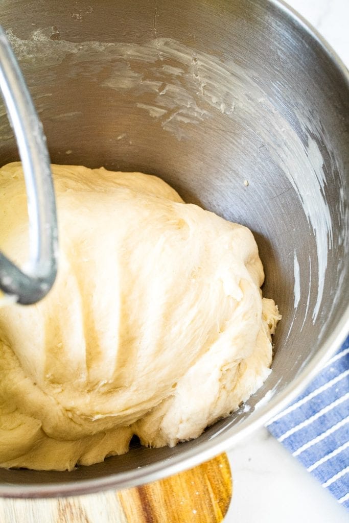 Dough showing hand print in metal mixing bowl