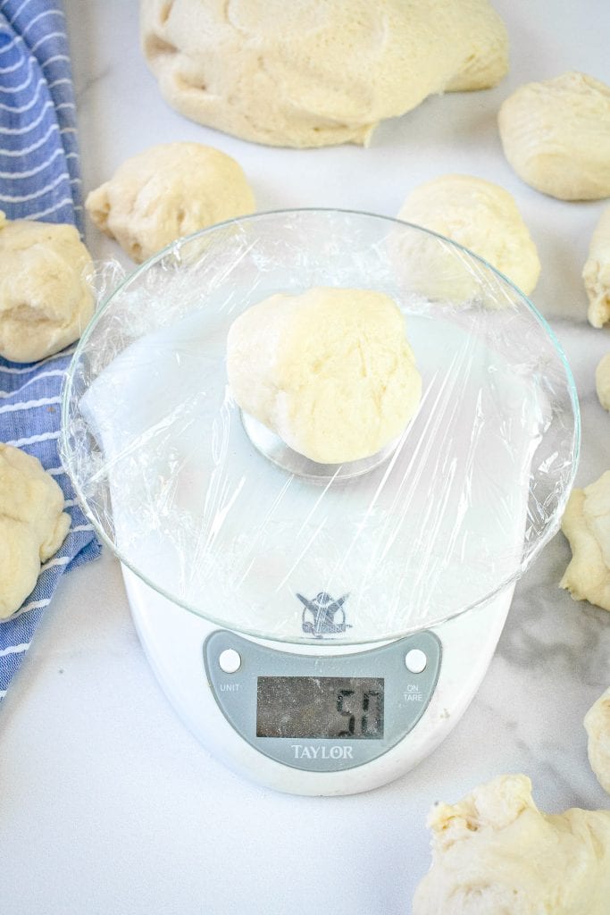 Kitchen scale with dinner roll dough on it