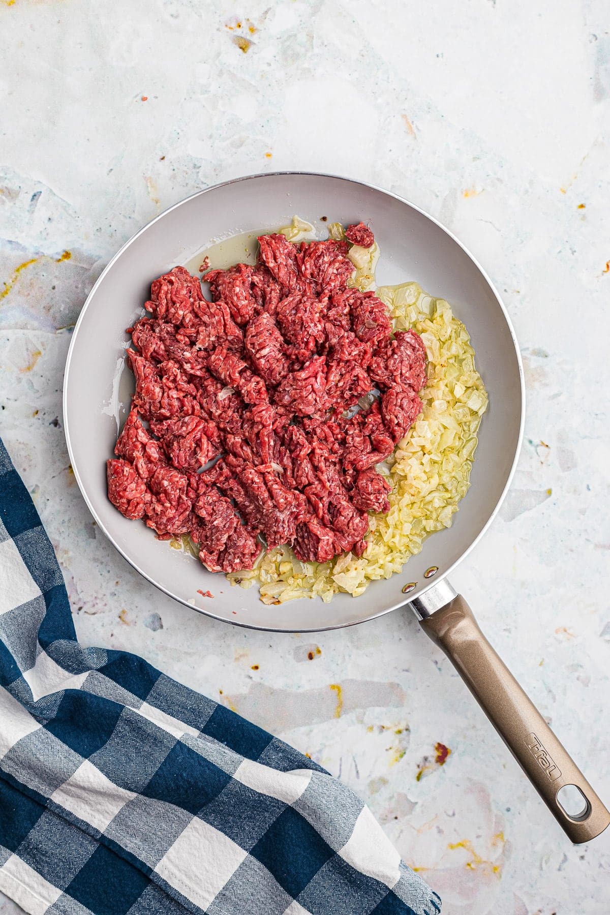 Ground beef, onions and garlic in skillet before browning.