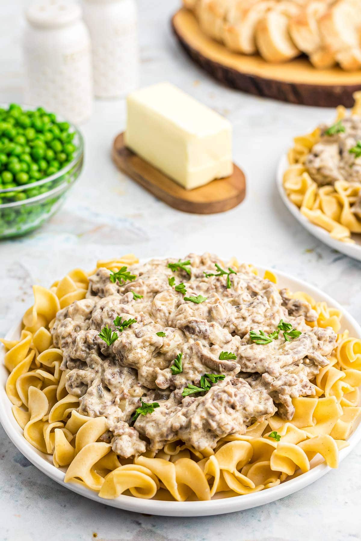 Hamburger Stroganoff on top of egg noodles on a whilte plate