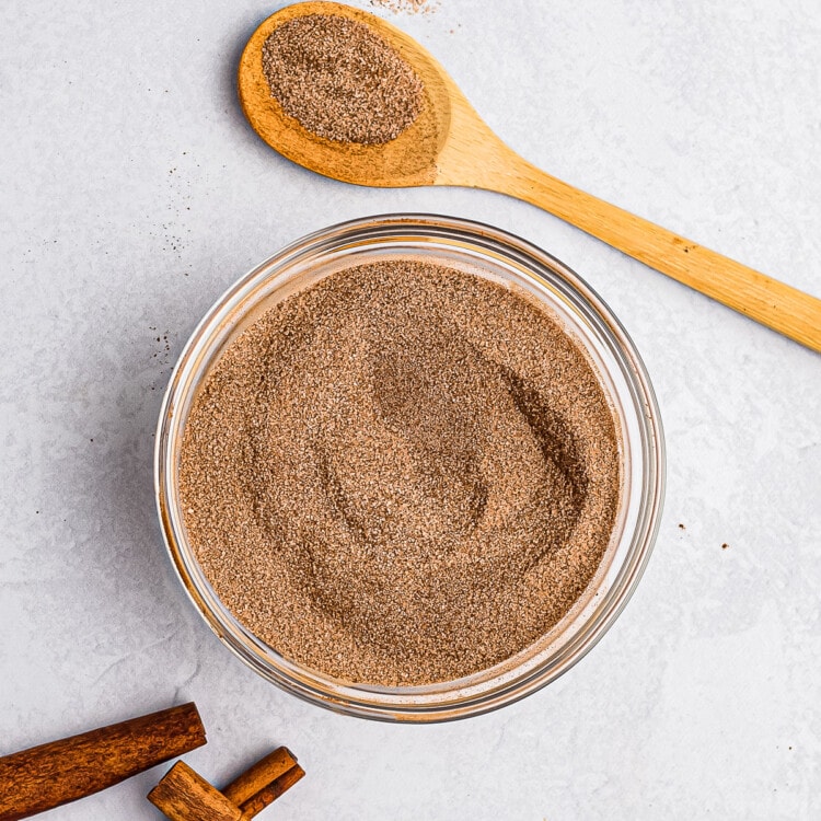 Glass bowl with cinnamon and sugar in it after stirring.