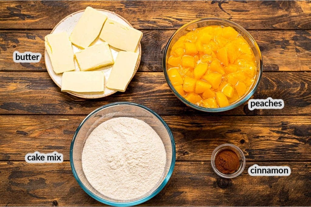 Overhead image showing peach pie filling, butter slabs, cake mix and cinnamon to make dump cake