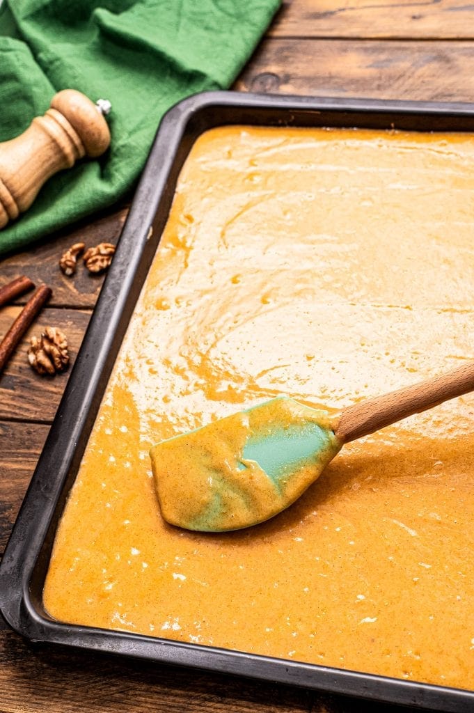 Spatula spreading pumpkin bars batter in pan