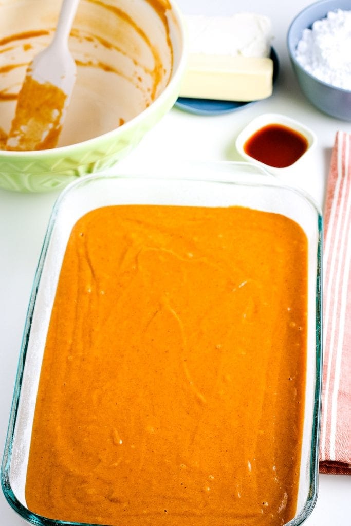 Pumpkin cake batter in glass rectangle baking dish.