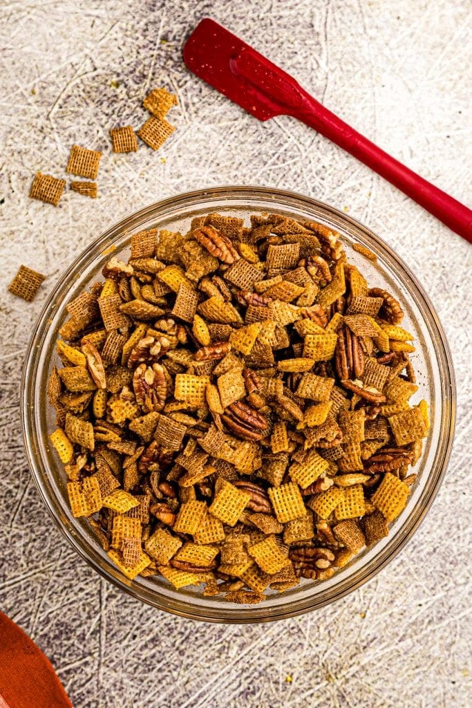 Overhead image of pumpkin chex mix in glass bowl.