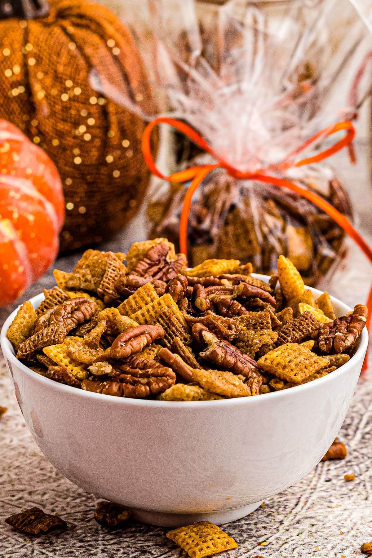 White bowl with pumpkin chex mix in it