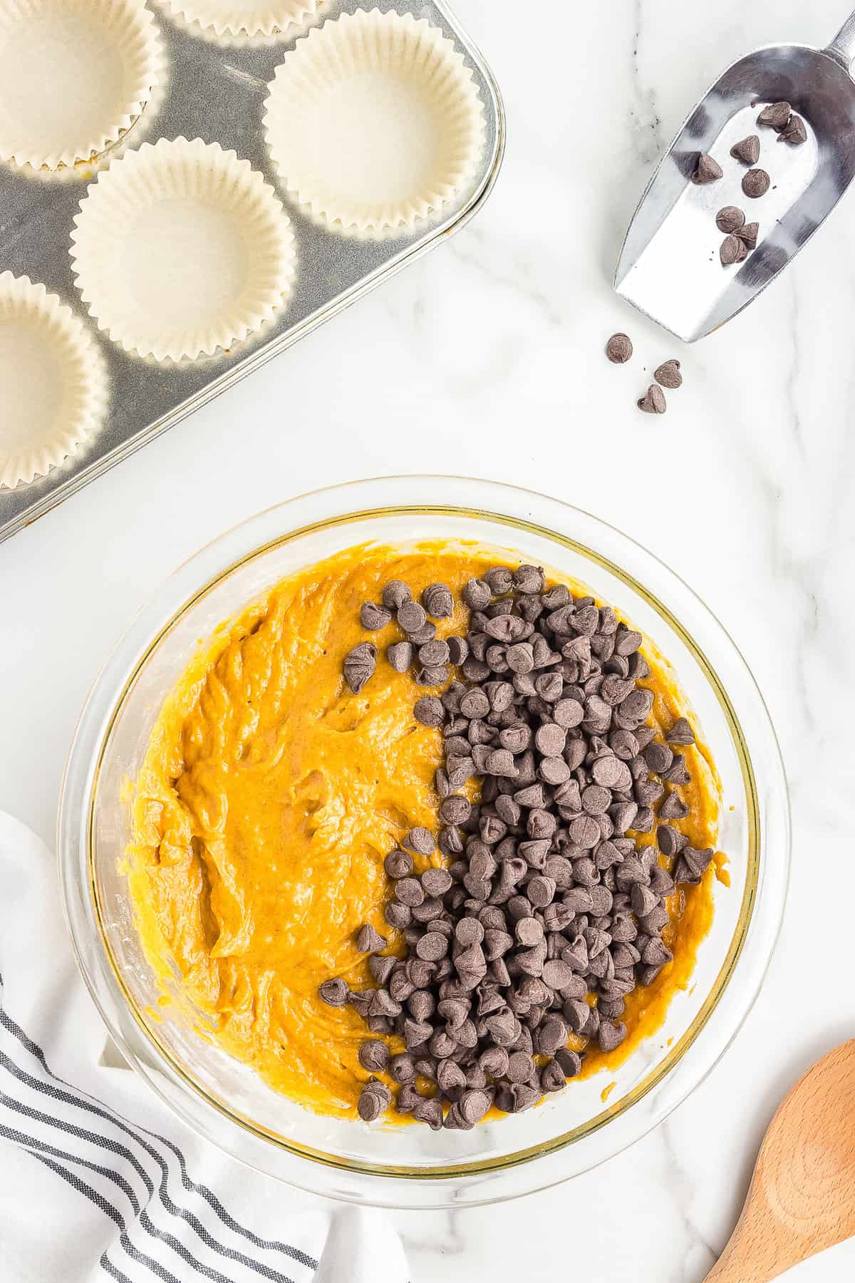 Pumpkin muffin batter with chocolate chips on top in bowl