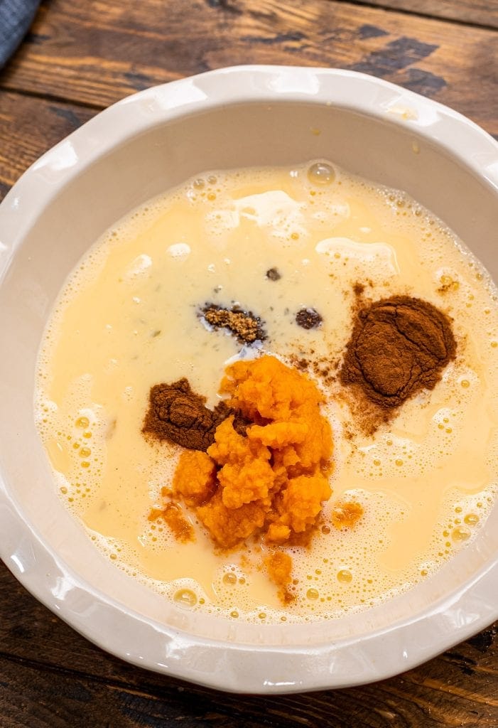 A white pie plate with french toast batter before whisking.