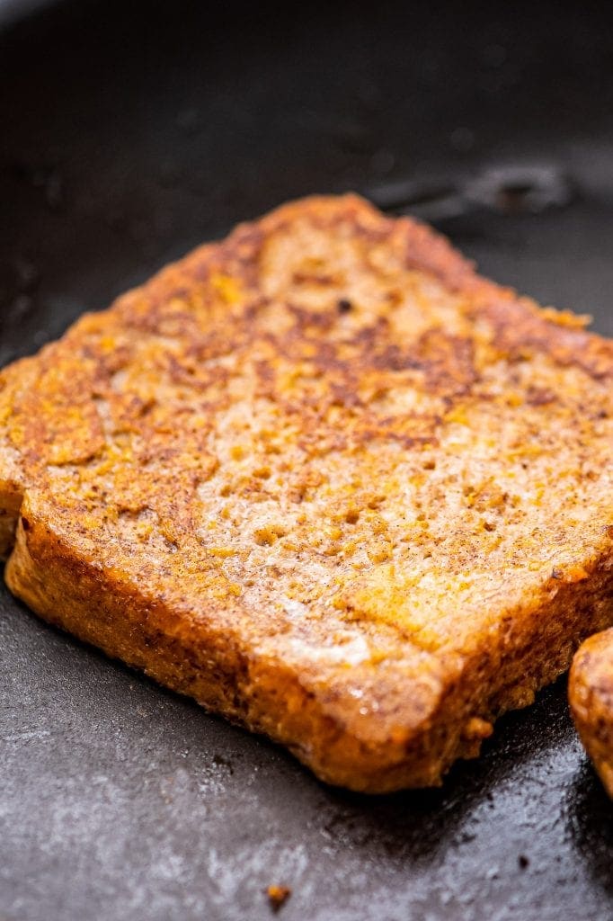 Close up of a piece of pumpkin french toast in skillet