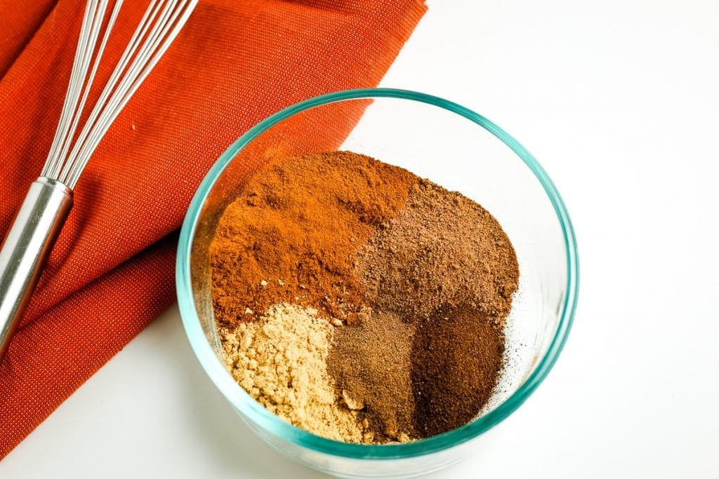 A glass bowl with spices in it to make pumpkin pie spice before mixing it together.