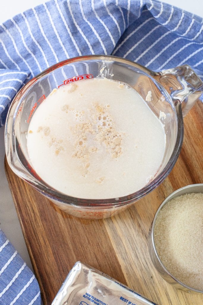 Glass measuring cup with yeast, water, sugar before mixing